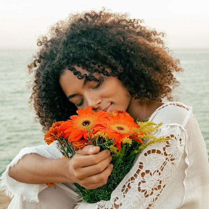 Lady with orange flower Lady breathing in a orange and yellow beautiful bouquet of flowers
